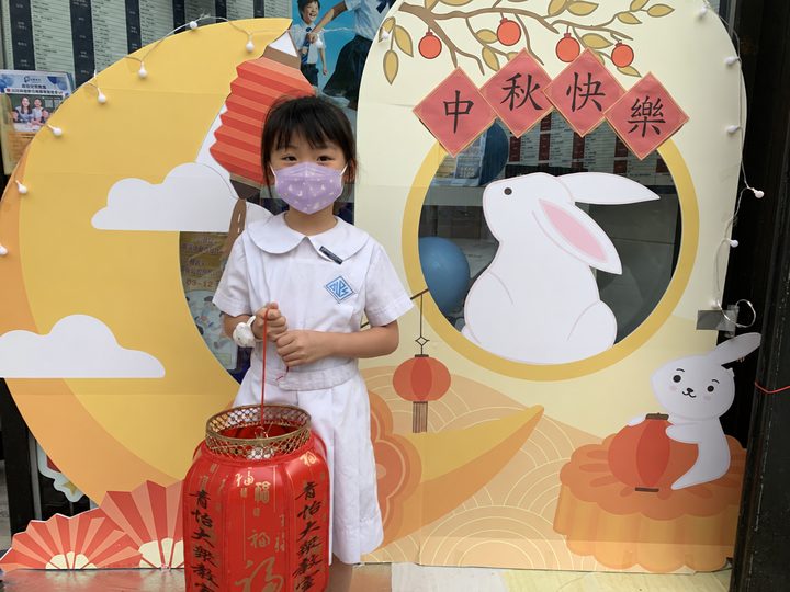 穿着白色校服的小朋友提着燈籠留影