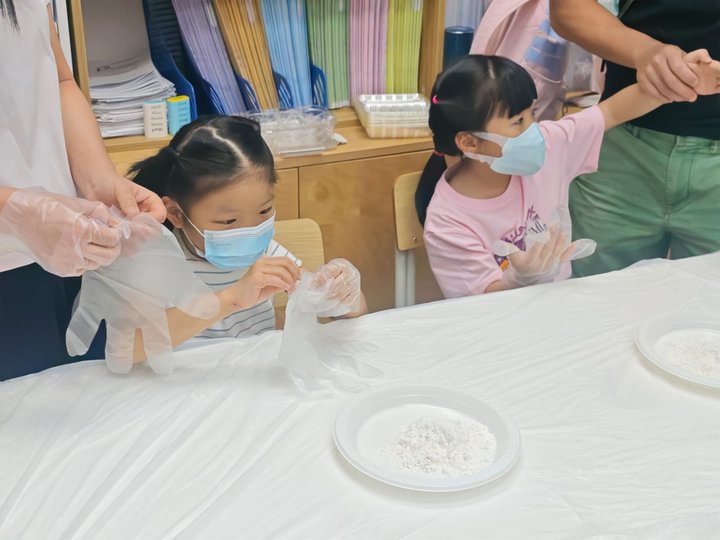 在大人的幫助下戴上手套。